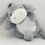 Thumbnail: Gray donkey plush toy laying with striped foot, wheat bags, toys.