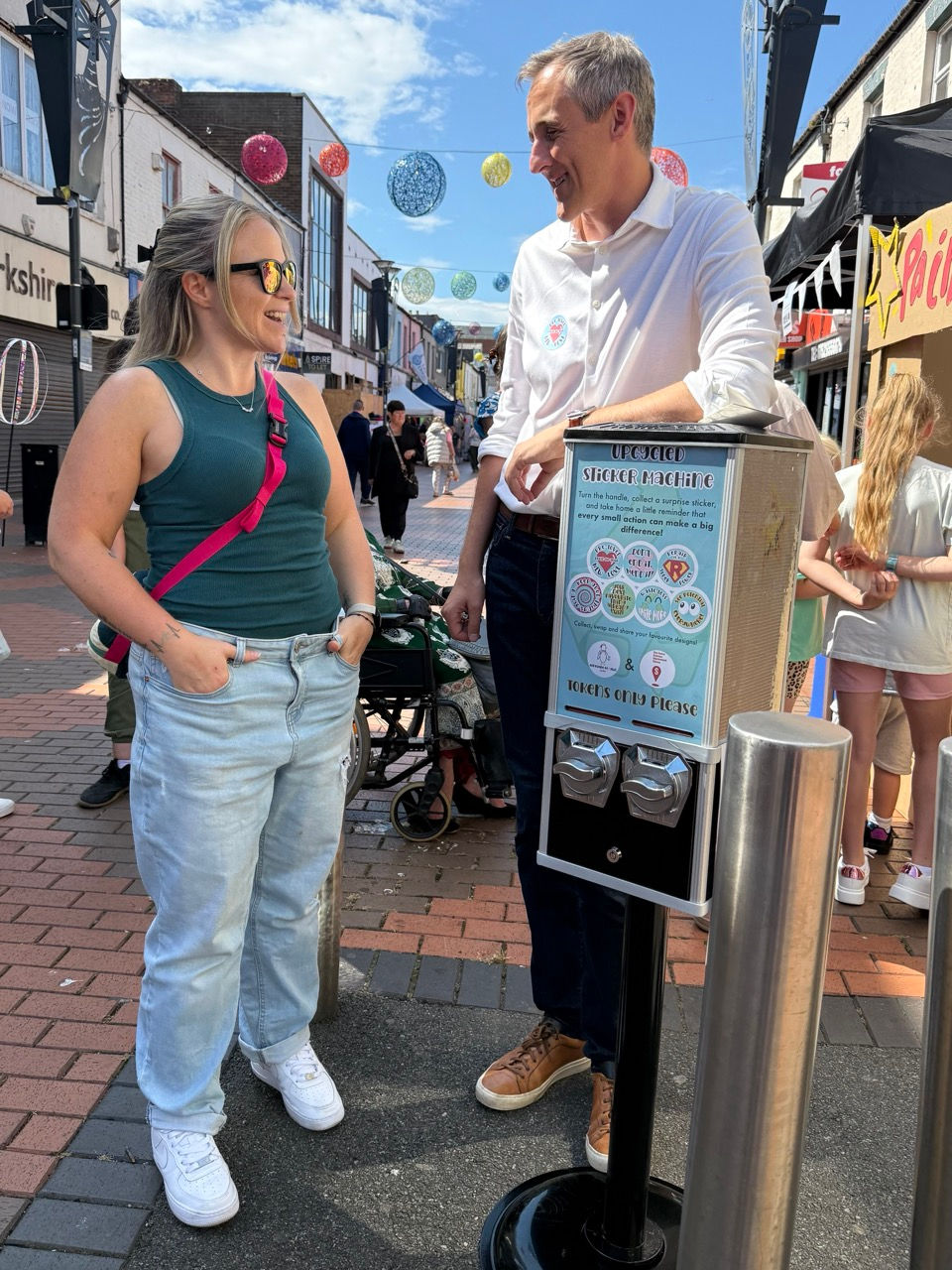 Sunderland MP Lewis Atkinson leaning on the mini-art vending machine chatting with Hels at the Blandford Street Party