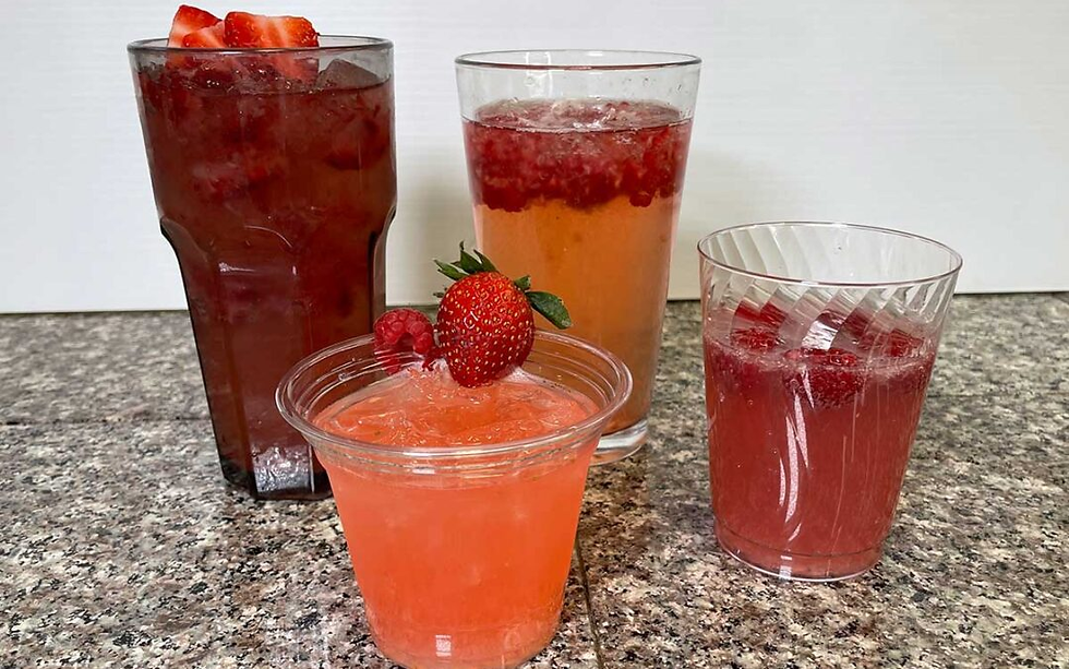 four pink and red cocktails on a counter