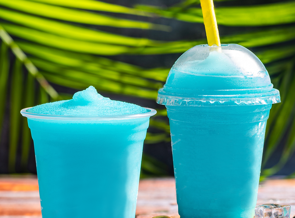 two blue slush drinks with tropical leaves behind