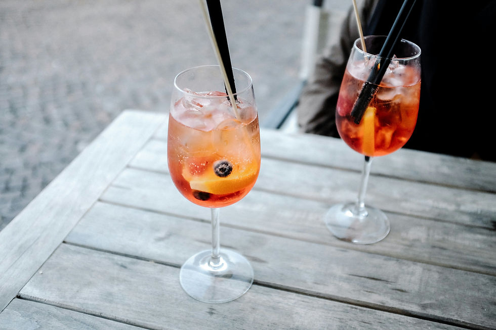 two cocktails in wine glasses on a table