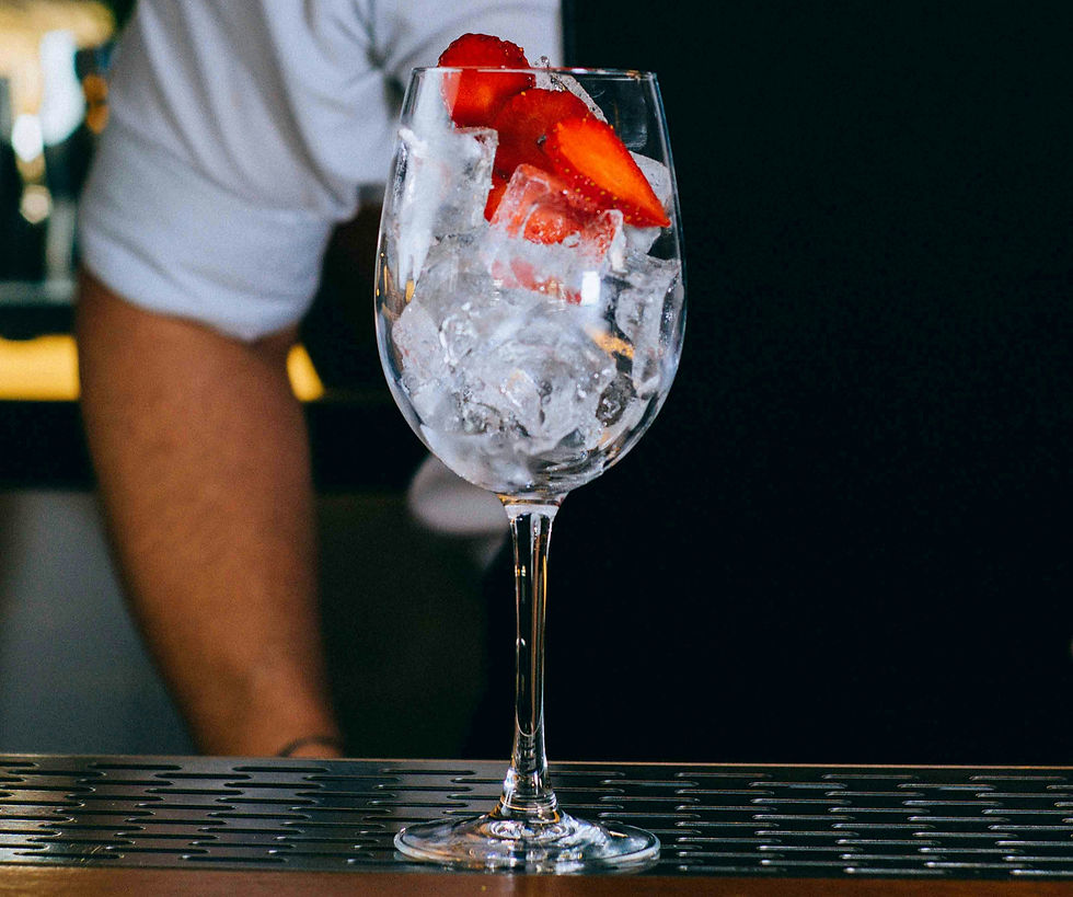 wine glass full of ice with strawberries on top on a bar counter