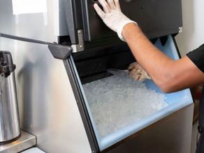 person scooping ice out of ice bin