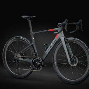 Bicicletta da corsa Ducati Monoscocca RR in carbonio grigio e nero, con dettagli rossi e ruote ad alto profilo, fotografata su sfondo scuro.