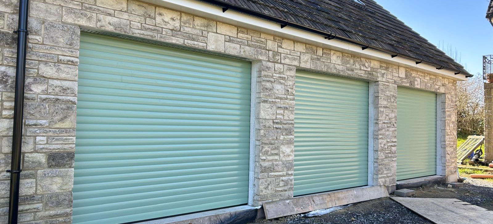 Three insulated 77mm aluminium roller garage doors in Chartwell Green installed by Garrolu