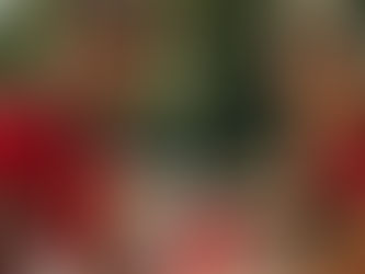 Volunteers in red shirts smiling and working together during a community service activity outdoors.