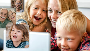 Child smiling and watching a birthday video with family while messages from friends and relatives appear on screen