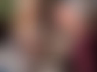 Friends gathered on a couch smiling and laughing while watching a video together, celebrating a 60th birthday.