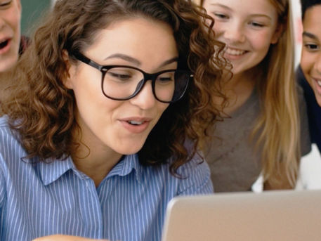Teacher watching a video with students during a classroom appreciation moment.