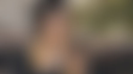 Graduate smiling while reading a message on her phone during a graduation ceremony.