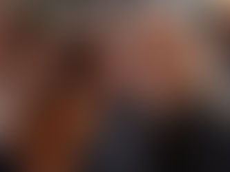 Woman laughing with coworkers while watching a retirement video together in an office.