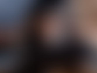 Graduate watching a personalized graduation video on a laptop with family behind him, reacting to a meaningful message.