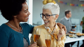 Coworkers celebrating a colleague’s retirement at an office gathering, sharing a warm moment of appreciation with drinks.