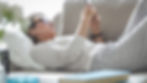 Woman resting on a sofa while reading a supportive message on her phone.