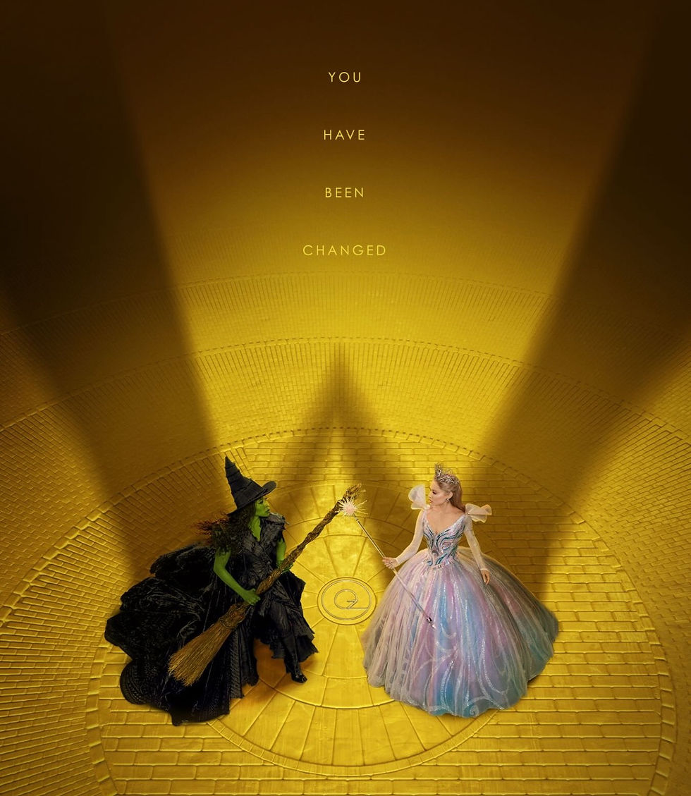 A dramatic overhead shot of Elphaba and Glinda standing on a bright yellow brick circular platform. Elphaba, dressed in black with a broom, faces Glinda, who wears a shimmering pastel ball gown and holds a wand. Their shadows form long silhouettes behind them, and above them the words “YOU HAVE BEEN CHANGED” appear vertically.