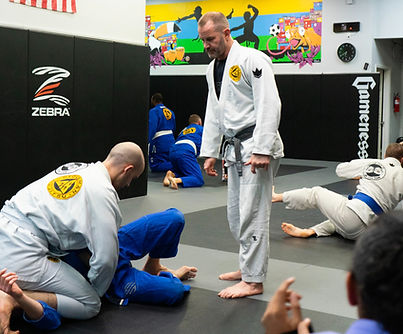 Head instructor Alan Stockman watching two students practice a Brazilian Jiu-Jitsu technique at Stockman Jiu-Jitsu in Greenwood, Indiana