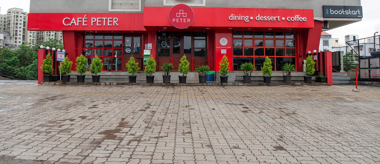 exterior of cafe peter in red colour with the plant infront