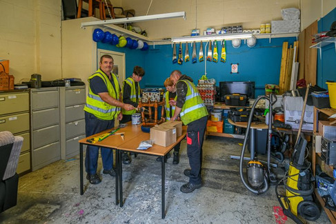 GAT volunteers working on a stool in a renovation workshop. 