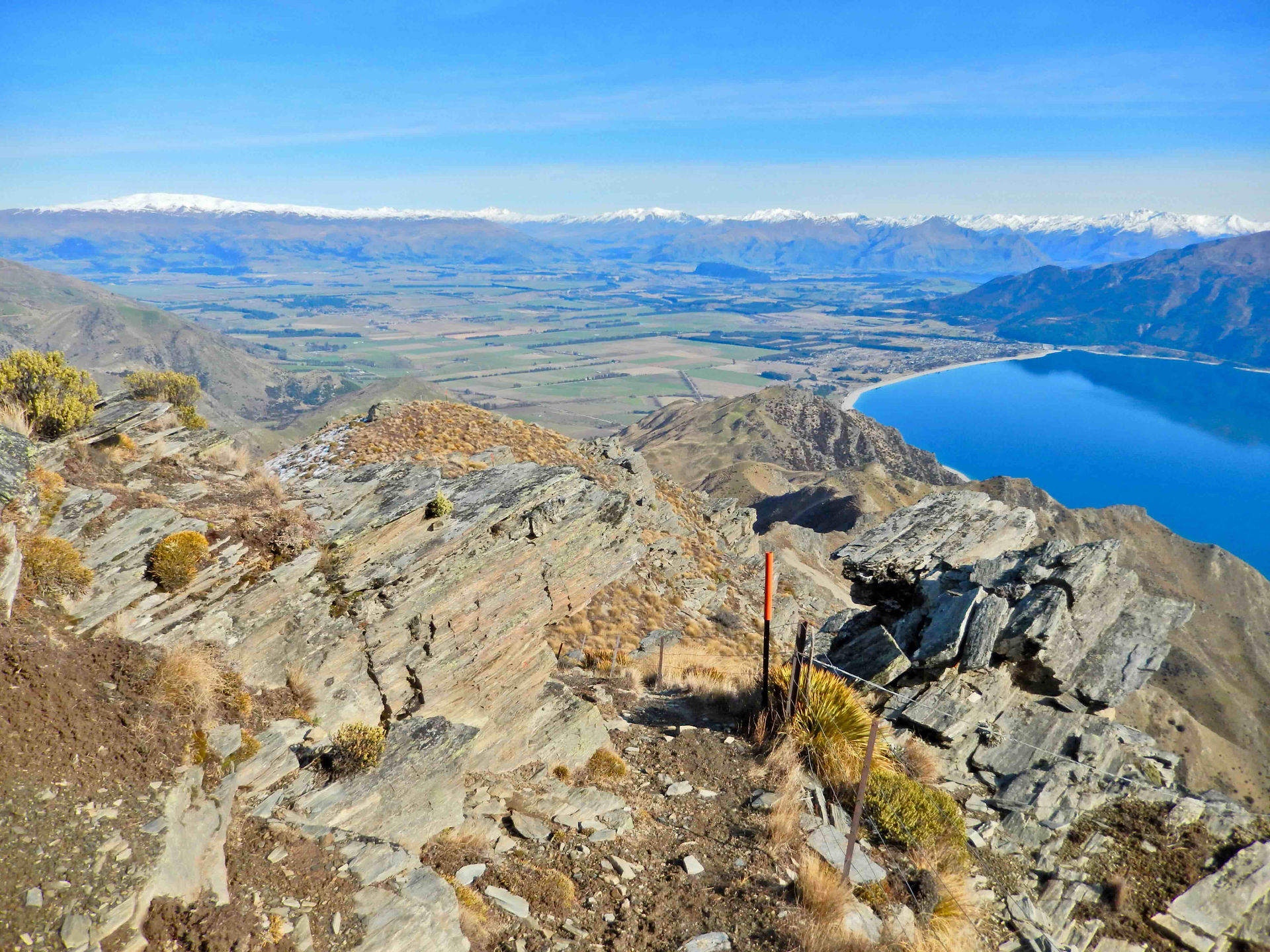 Widok ze szlaku Te Araroa do schroniska Pakituhi hut na zaśnieżone góry Crown Range i Lake Hawea w Nowej Zelandii na południowej wyspie