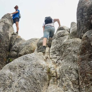 Turyści wspinający się po głazach na szczyt The Pinnacles na szlaku trekkingowym Kauaeranga Kauri Trail na półwyspie Coromander na północnej wyspie Nowej Zelandii