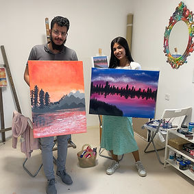 Couple in a art studio with a painting on a canvas of view in purple and orange colors