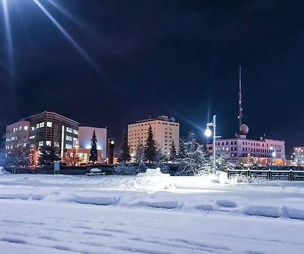 Snowy ground and commercial, condominium, and office buildings in Fairbanks, Alaska.