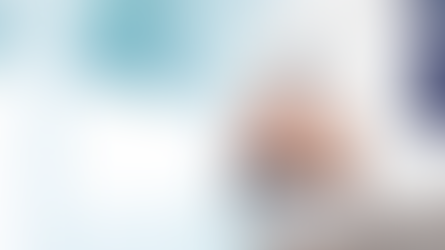 Doctor in a white coat, arms crossed, holding a stethoscope. Professional setting with a blurred window background, conveying calm.