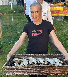 Owner and staff member, Julie, serving guests at a wood-fired catering event