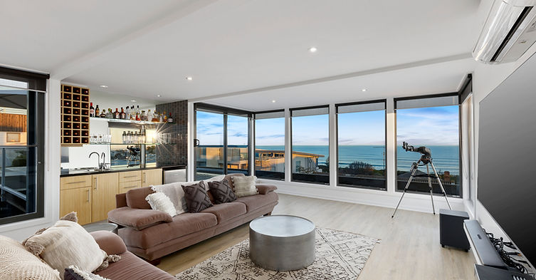 Top-floor lounge and bar with floor-to-ceiling windows and panoramic Ocean Grove views