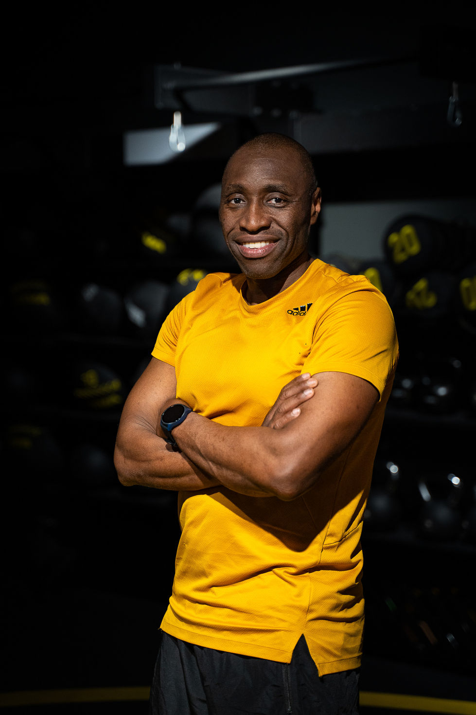 Modèle fitness homme posant dans une ambiance brute et industrielle de salle de sport.