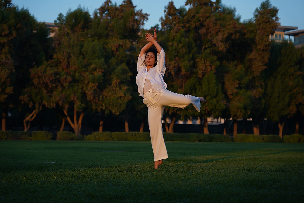 Woman in white leaping in a park