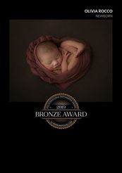 Newborn baby swaddled in pink heart blanket with delicate headband – Hertfordshire newborn photography award image.