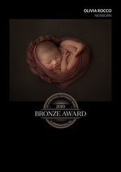 Newborn baby swaddled in pink heart blanket with delicate headband – Hertfordshire newborn photography award image.