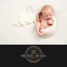 Bronze award newborn photograph of baby in side pose on cream blanket – Olivia Christina Photography, Hertfordshire.