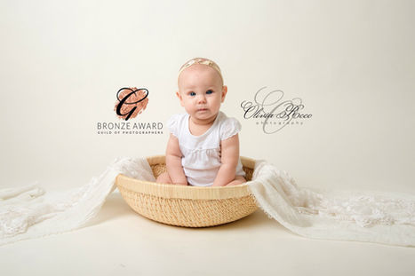 Bronze award - Smiling baby in wooden bowl with cream drape – Olivia Christina Photography, Hertfordshire newborn photographer.