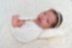 Newborn Photographer in Hertfordshire / baby peacefully sleeping in a soft, neutral-toned wrap during a natural light photography session in Stevenage, Hertfordshire. Timeless baby portrait by award-winning newborn photographer Olivia Christina, serving St Albans, Harpenden, Hitchin, Welwyn Garden City, and surrounding areas.