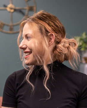 Image of client in the hair spa with a loose messy bun hairstyle looking over their shoulder 