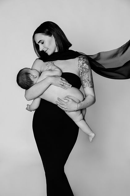 ritratto in bianco e nero di maternità di una mamma con in braccio la sua bambina che la guarda emozionata durante una sessione motherhood e famiglia a Modena