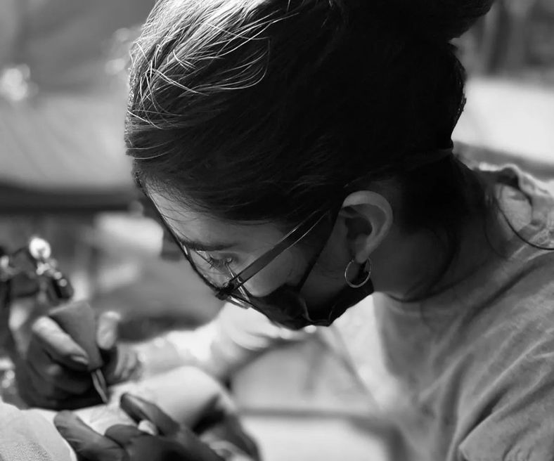 Mujeres grabando su arte en la piel