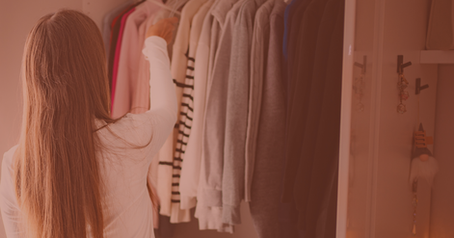 This woman standing in front of her closet has an easier time answering decluttering questions by creating a structure before she starts.