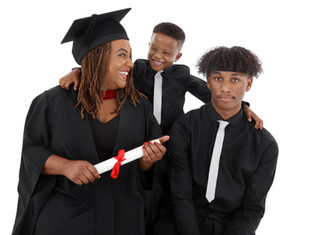 family of four being photographed on a white background. one lady in a graduation gown and hat