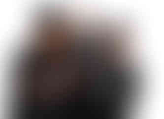 family of four being photographed on a white background. one lady in a graduation gown and hat