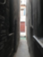 Narrow alleyway looking out to open door
