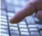 Finger pressing a white keyboard key with a curved arrow symbol, close-up. Blue-toned lighting suggests a modern tech mood.