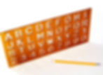 Orange stencil with alphabet and numbers, beside a yellow pencil. White background highlights the vibrant colors and clean design.