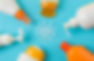 Sunscreen bottles arranged in a circle on a blue background with lotion forming a sun shape, displaying a cheerful and sunny theme.