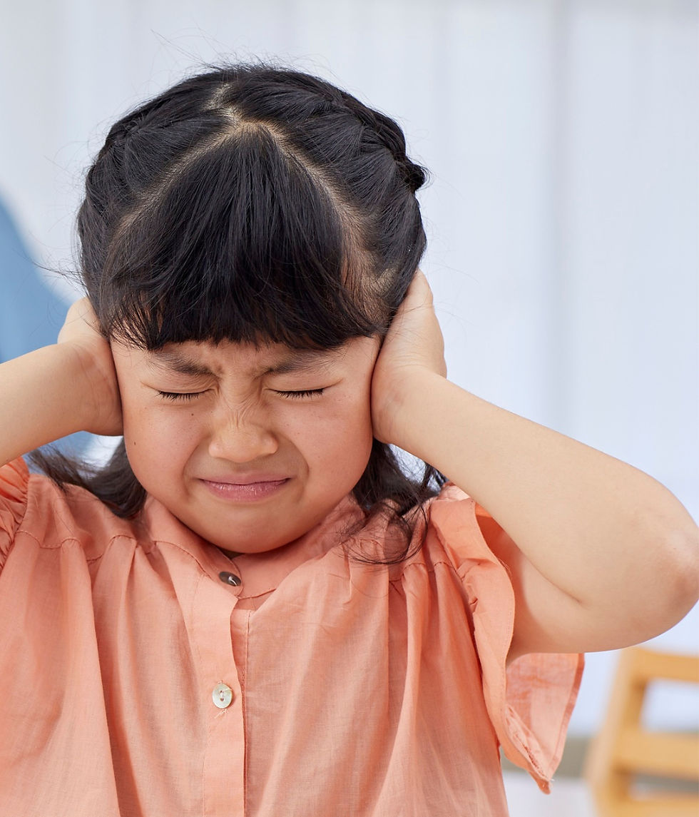Child covering ears during a holiday gathering — autism and holiday sensory overload.