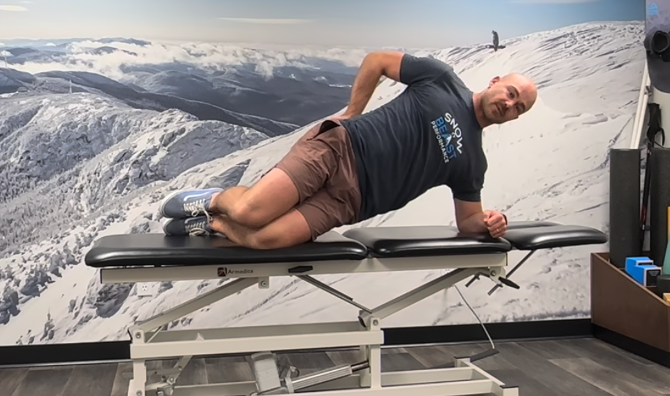 Side plank exercise for low back pain showing final position of head, neck, shoulders, trunk, hips, and knees