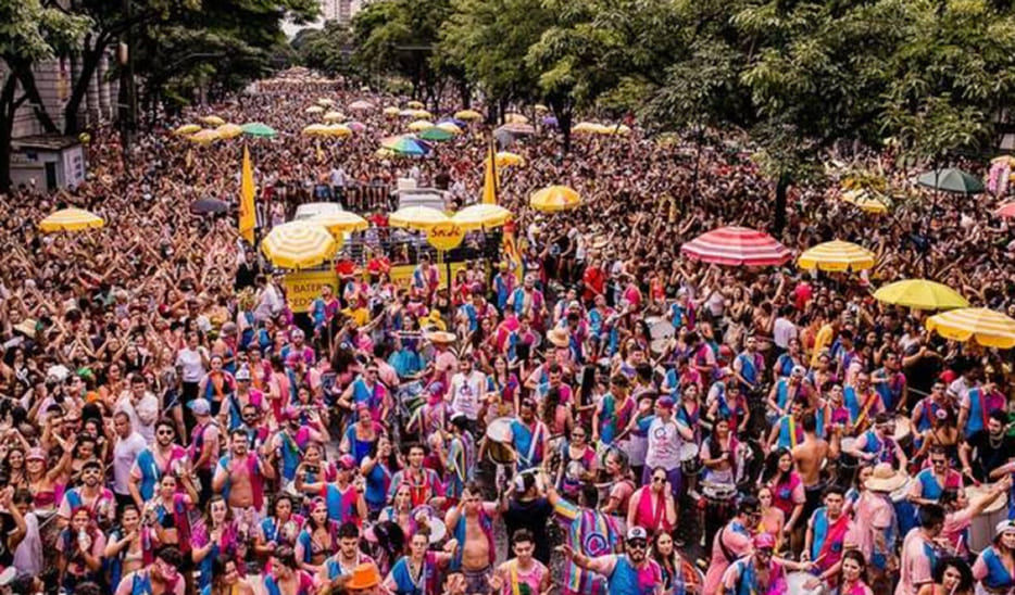 Rua movimentada com foliões celebrando o Carnaval.