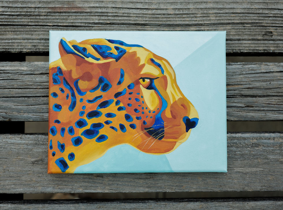 yellow and orange cheetah with blue spots and a light teal background, sitting on wood